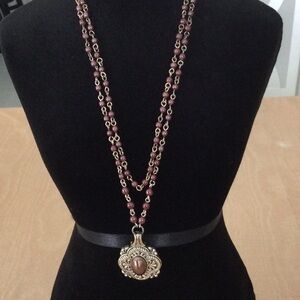 Woman’s Necklace Brown Beads on a gold color chain.